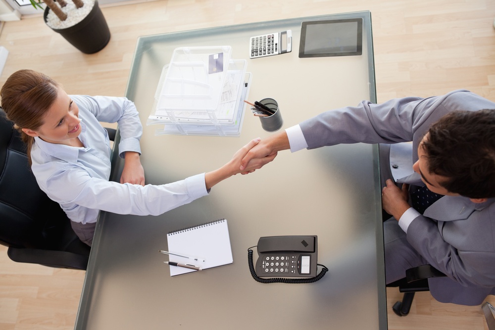 Above view of young consultant shaking hands with customer